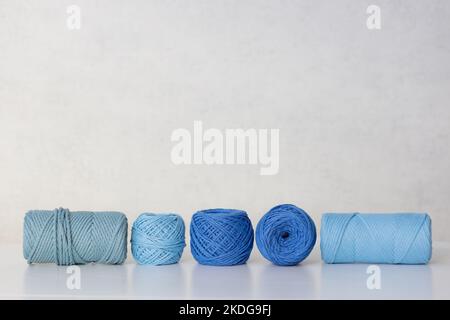 Cotton ropes and spools of various sizes for needlework and macrame in blue and blue colors Stock Photo