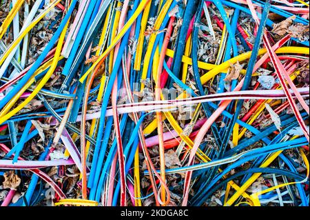 Multi-coloured striped wire casings scattered on the ground like rainbow coloured spaghetti Stock Photo