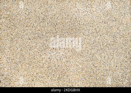Perfectly flat and uniform wet sand texture on a beach creating a grainy backdrop Stock Photo