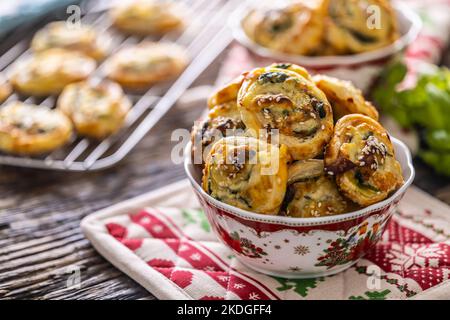 Christmas savory pastries, mini pizza cakes in a typical Christmas dish and festive decorations. Stock Photo