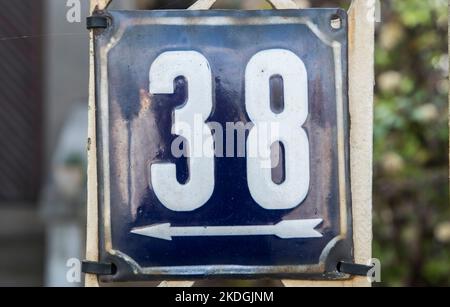 Weathered grunge square metal enameled plate of number of street address with number 38 Stock Photo