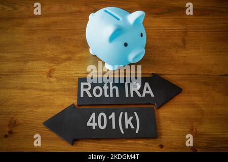 Piggy bank and arrows with signs Roth IRA and 401k retirement plan. Stock Photo