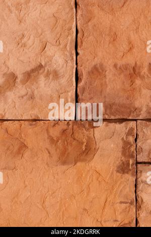Exterior stone wall tile with natural rock and straight joint lines. Rough brown textured block surface. Abstract background. Copy space Stock Photo