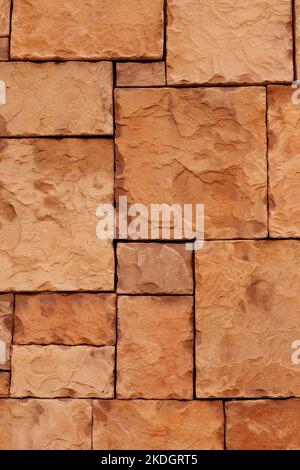 Stone wall tile with natural rock and straight joint lines. Rough sandstone brown block surface. Stock Photo
