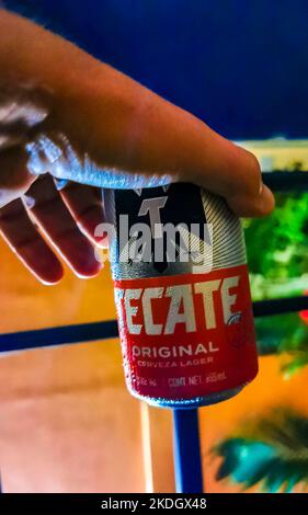 Drinking a can of cold beer Tecate red on the beach in paradise in Playa del Carmen Quintana Roo Mexico. Stock Photo