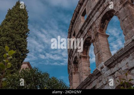 Beautiful roman colloseum or amphiteatre in Pula on a sunny summer evening with romantic feeling. Details parts of beautiful roman structure in golden Stock Photo