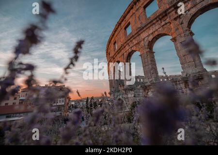 Beautiful roman colloseum or amphiteatre in Pula on a sunny summer evening with romantic feeling. Details parts of beautiful roman structure in golden Stock Photo