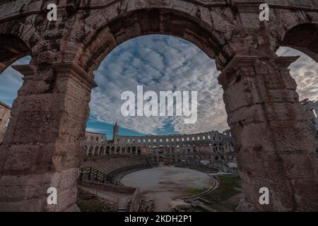 Beautiful roman colloseum or amphiteatre in Pula on a sunny summer evening with romantic feeling. Details parts of beautiful roman structure in golden Stock Photo