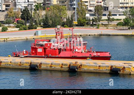 Piraeus, Athens, Greece - June 2022: Tug boat with firefighting water cannons moored in the port of Piraeus. Stock Photo