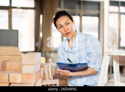 Woman making notes at renovating house Stock Photo