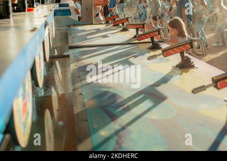 focused young girl playing carnival game Stock Photo