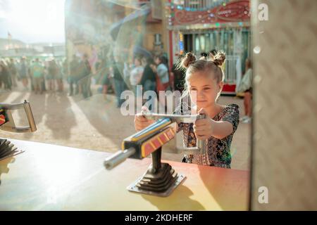 Young girl playing a carnival game on sunny day Stock Photo