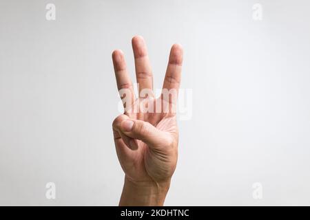 Pointing up with fingers number three. Close up, isolated on white background. Stock Photo