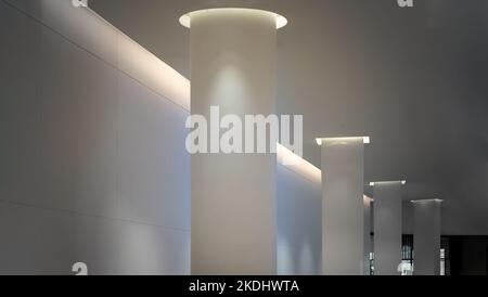 Bangkok, Thailand - Sep 30, 2022 : Concrete interior space with white round pillars arranged long lines lighting cast the shadow on the wall and pilla Stock Photo