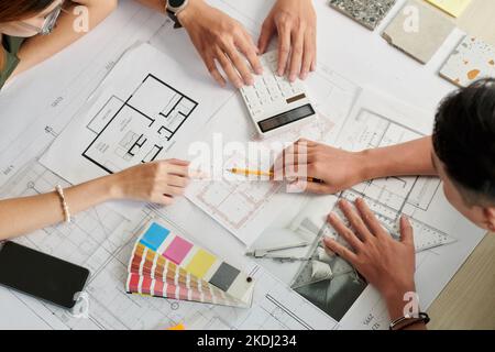 Hands of architects working on house blueprint and making calculations Stock Photo
