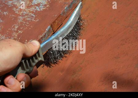 https://l450v.alamy.com/450v/2kdj4xy/builder-remove-old-paint-and-cleaning-surface-from-dust-on-metal-roof-with-metal-brush-before-painting-2kdj4xy.jpg