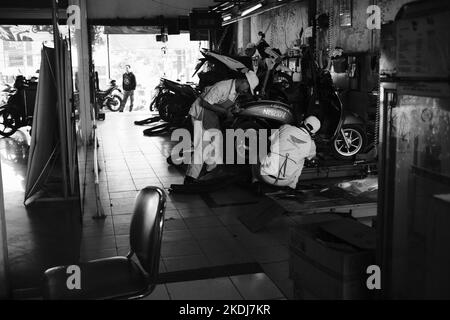 Cikancung, West Java, Indonesia - 24 October, 2022 :Black and white photo, Monochrome photo of a mechanic repairing a motorbike Stock Photo