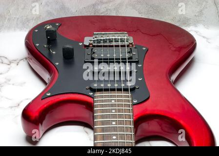 Red electric guitar isolated on marble background Stock Photo
