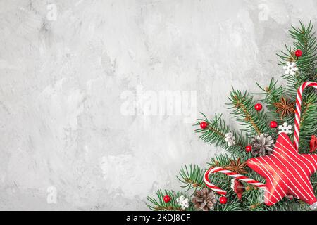 Christmas background. Fir tree, festive decorations, red star on gray concrete background. Flat lay. Top view with copy space. Winter holidays concept Stock Photo