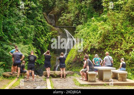 A group of tourists at Wigmore's Waterfall, the only waterfall on the islands of Rarotonga, Cook Islands Stock Photo