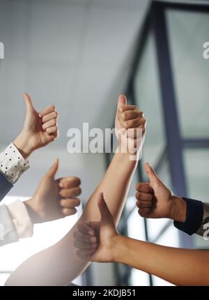 Impressive work. a group of unrecognisable businesspeople showing thumbs up. Stock Photo