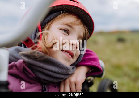 Portrait of happy little girl with helmet on bicycle. Stock Photo