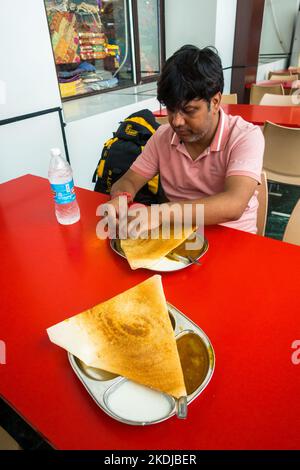 July 5th 2022 Katra, Jammu and Kashmir, India. A man enjoying South Indian masala dosa at Shri Mata Vaishno Devi Railway Station Katra . Stock Photo