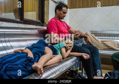 July 5th 2022 Katra, Jammu and Kashmir, India. A man with his sleeping kids at the Railway Station waiting Room. Stock Photo