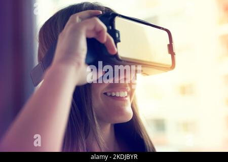 Take an adventure through the landscape of your imagination. a young businesswoman wearing a VR headset in an office. Stock Photo