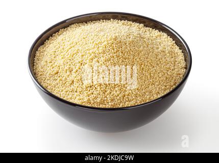Uncooked couscous in black bowl isolated on white background with clipping path Stock Photo