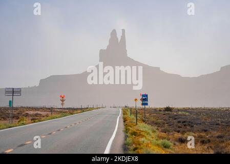 Signboards by highway leading towards geological features in Monument Valley Stock Photo