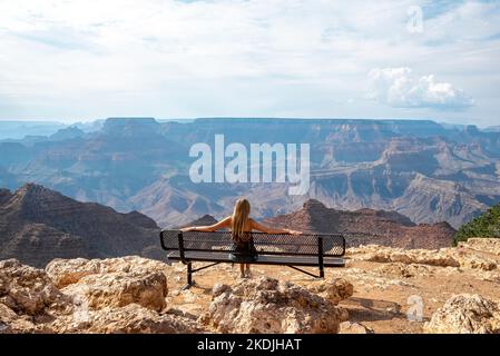 Woman Looking At Grand Canyon While Sitting On Bench Stock Photo