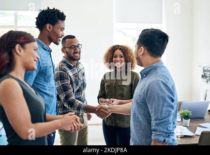 Another successful negotiation in the bag. happy colleagues shaking hands in a modern office. Stock Photo