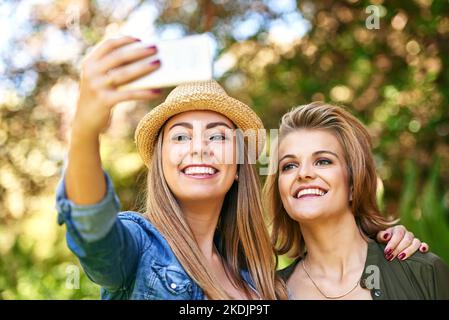Take another one. two attractive young women taking selfies outside. Stock Photo