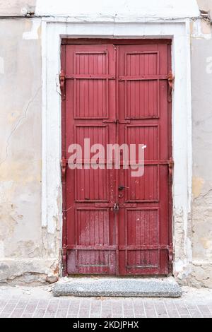 Big red front door. Destroyed building wall Stock Photo
