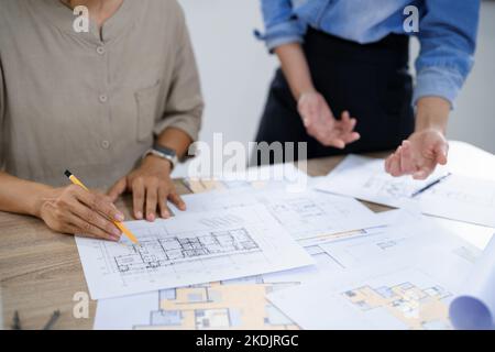 Concept of engineering consulting, Two female engineers discussing about blueprint of condominium. Stock Photo