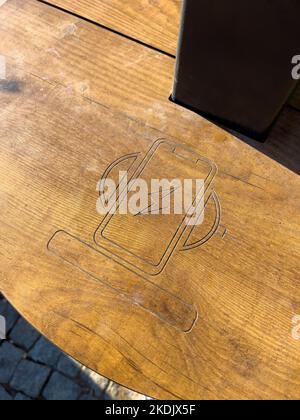 Public wireless smartphone station on wooden table Stock Photo