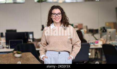 Young happy professional business woman standing in office, portrait. Stock Photo
