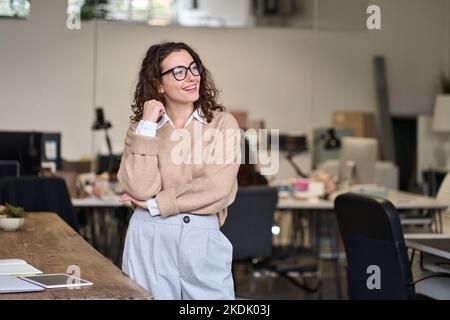Young positive happy professional business woman standing in office. Stock Photo