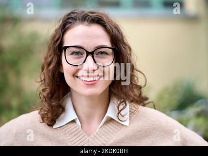 Young smiling professional business woman standing outdoor, headshot portrait. Stock Photo
