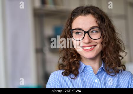 Young smiling interested professional business woman looking away at copy space. Stock Photo