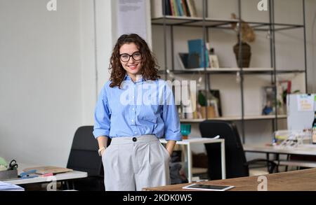 Young smiling business woman manager standing in office, portrait. Stock Photo