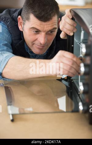 man repairing an electric oven Stock Photo