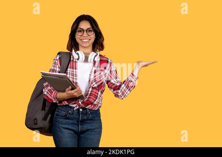 Positive young arab lady student showing copy space Stock Photo