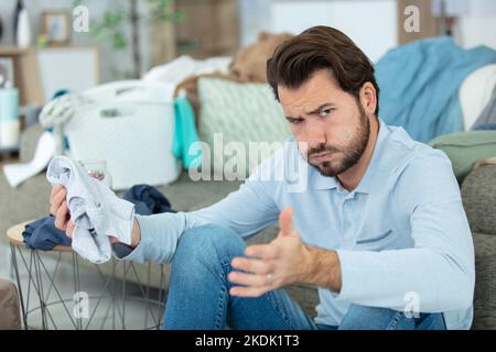 angry young man dislikes laundering Stock Photo