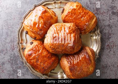 Delicious french buns Croissants Pain Au Chocolate closeup in the plate on the table. Horizontal top view from above Stock Photo