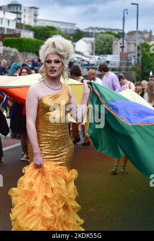 A flamboyant Drag Queen leading the vibrant colourful Cornwall Prides Pride parade in Newquay Town centre in the UK. Stock Photo