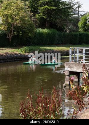 Lokeren, Belgium, August 27, 2022, two girls are sailing in green canoes on the river Durme in Lokeren Stock Photo