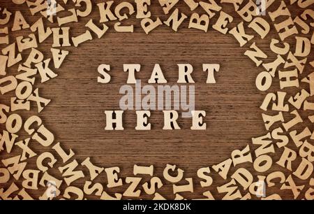 Start Here phrase made with wooden letters on table, concept. Stock Photo