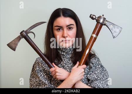 London, UK.  7 November 2022. A staff member with (L) ‘A rare North American tomahawk’, late 18th century, (Est. £3,000 - £4,000) and ‘A very rare and fine North American pipe tomahawk’, late 18th century, (Est. £8,000 - £10,000) at a photocall of Bonhams Arms and Armour sale which includes the Chris Wynn collection of early Purdeys. The auction will take place at Bonhams Knightsbridge on 9 November.  Credit: Stephen Chung / Alamy Live News Stock Photo